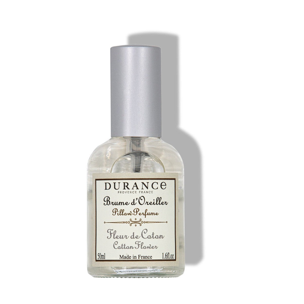 A clear spray bottle labeled 'Durance Brume de Doster Pillow Perfume Cotton Flower', indicating a fragrance for pillows, made in France.